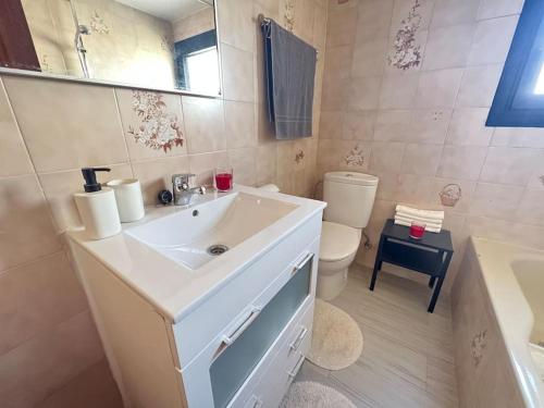 a bathroom with a sink and a toilet and a mirror at Playamar Feliz in Torremolinos