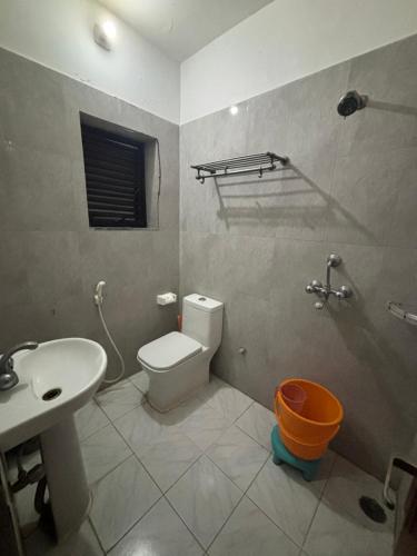 y baño con aseo blanco y lavamanos. en Lucky Guest House Bodhgaya, en Bodh Gaya