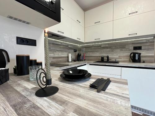 eine Küche mit weißen Schränken und Holzböden in der Unterkunft Апартамент Божур in Warna