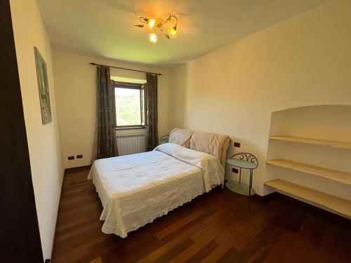 a small bedroom with a bed and a window at Casa Berton in Mochignano
