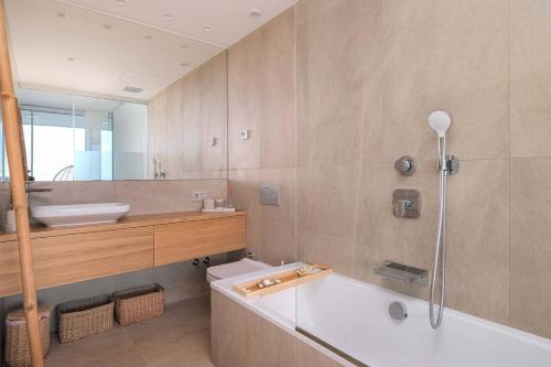 y baño con bañera, aseo y lavamanos. en Med Two luxury apartment with sea view, en Fuengirola