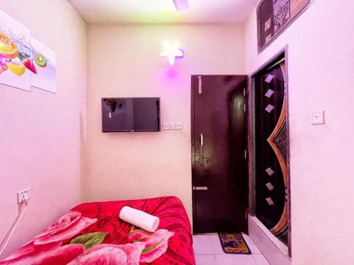 a room with a bed and a door with a television at Hotel Shogondha Residential, in Dhaka