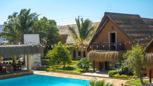a villa with a swimming pool in front of a house at LE VAHINÉ Eco-RESORT in Toliara