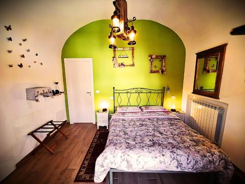 1 dormitorio con cama y pared verde en Chrizia, en Novi Ligure