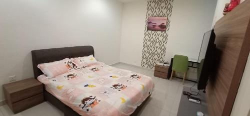 een slaapkamer met een bed met een roze dekbed bij Kozi Square with Infinity Pool I Kuching in Kuching