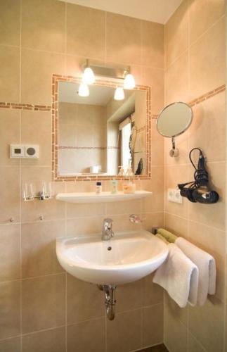 La salle de bains est pourvue d'un lavabo et d'un miroir. dans l'établissement Ruhige und doch zentral gelegene Ferienwohnung in alpiner Lage, à Reit im Winkl