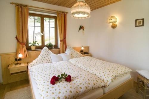 - une chambre dotée d'un lit avec deux roses dans l'établissement Ruhige und doch zentral gelegene Ferienwohnung in alpiner Lage, à Reit im Winkl