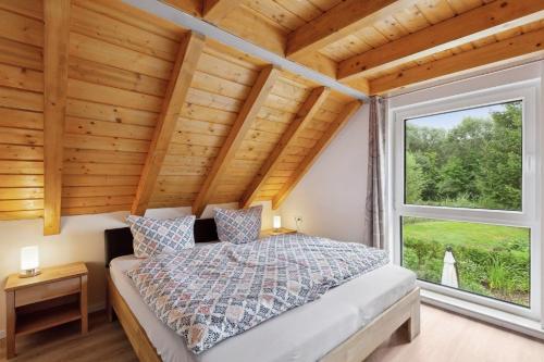 a bedroom with a bed and a large window at Ferienhaus in Krimderode mit Grill, Whirlpool und Terrasse in Nordhausen