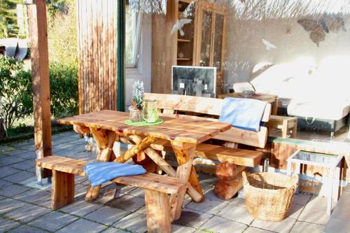 uma mesa de madeira e bancos num pátio em Ruhig gelegener Ferienbungalow mit Terrasse und Garten am Waldrand em Bad Elster