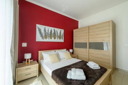 Is-SwieqiにあるBreathtaking Penthouse Crimson Court Bの赤い壁のベッドルーム1室(大型ベッド1台付)