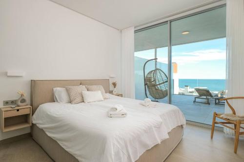 フエンヒロラにあるMed Two luxury apartment with sea viewの海の見えるベッドのある寝室