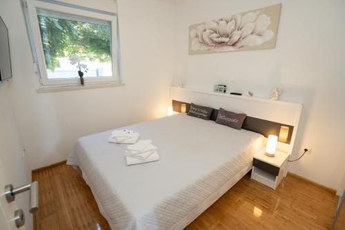 a bedroom with a large white bed with a window at Adriatic Escape Novalja-Zrce! in Novalja