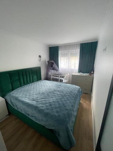 a bedroom with a bed with a green headboard at Appartement 3 pieces 2 minutes à pied RER vers Paris in Gagny