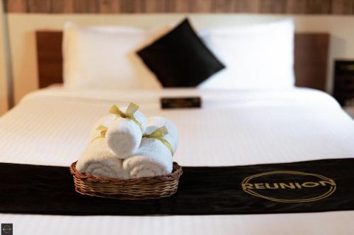 a basket of towels sitting on top of a bed at Reunion Ocean Bliss in Udupi