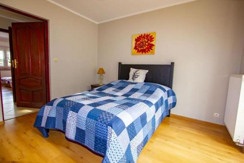 a bedroom with a blue and white checkered bed at Villa Aruba in Grzybowo