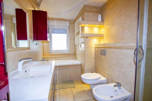 a bathroom with a sink and a toilet and a tub at Villa Aruba in Grzybowo