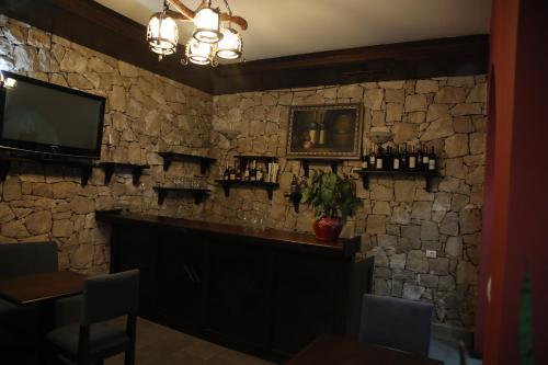 a bar in a restaurant with a stone wall at Pamja e Qyteteve in Krujë