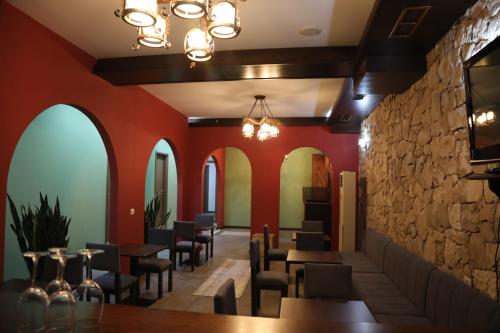 a restaurant with red walls and tables and chairs at Pamja e Qyteteve in Krujë