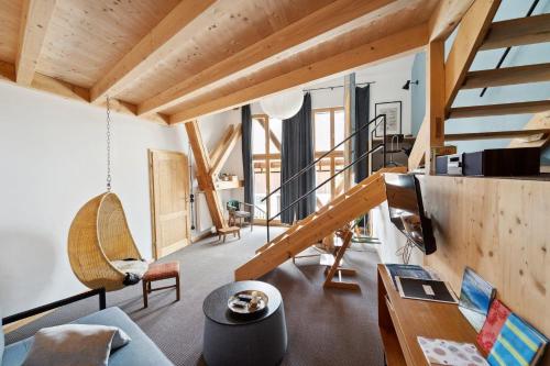 a living room with wooden ceilings and a staircase at Ferienwohnung Oderding in Polling