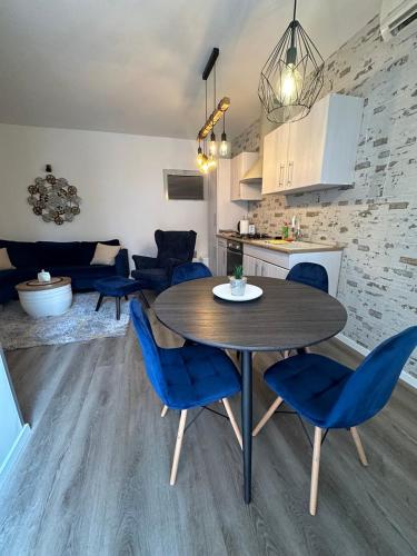 a kitchen and dining room with a table and blue chairs at Villa Nada in Lovran