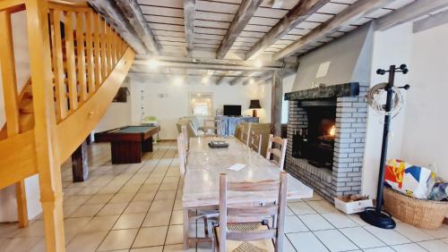 une salle à manger avec une table et une cheminée dans l'établissement Hangy bas & spa, à Fresse-sur-Moselle