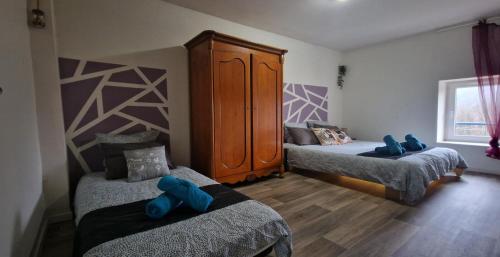 Fresse-sur-MoselleにあるHangy bas & spaのツインベッド2台とキャビネット付きのベッドルーム1室が備わります。