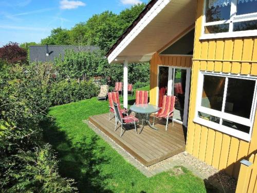 a patio with a table and chairs on a deck at Gemütliches Ferienhaus Alissa für 5 Personen mit Sauna und Kaminofen von Privat im Ferienpark Extert in Extertal