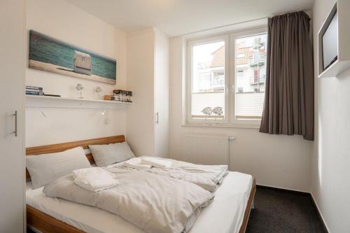 a bed in a bedroom with a window at Strandpark-Grossenbrode-Haus-Moewennest-Wohnung-2 in Großenbrode