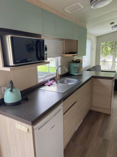 a kitchen with a sink and a microwave at Wetter_wille in Earnewâld