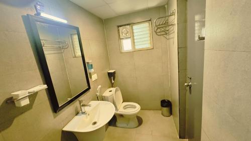 a bathroom with a toilet and a sink and a mirror at PHP BOUTIQUE TOWNHOUSE in Chennai