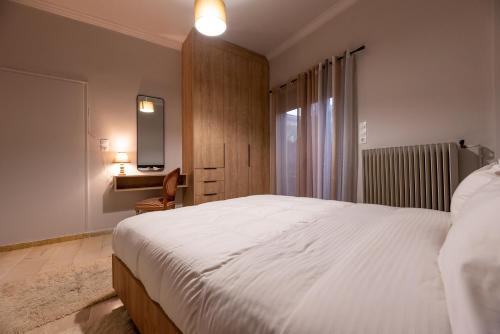 Un dormitorio con una gran cama blanca y una ventana en STAMOS Apartment airport en Spáta