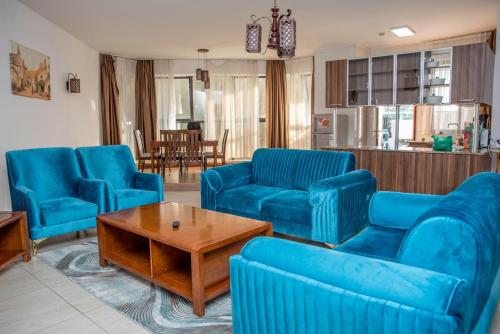 ein Wohnzimmer mit blauen Stühlen und einem Tisch in der Unterkunft Kilimani Extended Stays in Nairobi