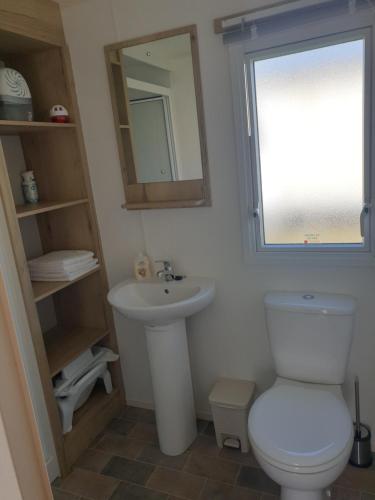 ein Badezimmer mit einem WC, einem Waschbecken und einem Spiegel in der Unterkunft Our Happy Place! in Weymouth