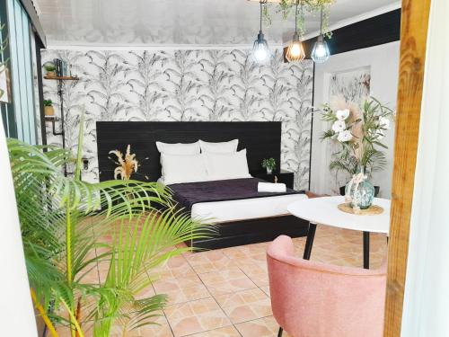 Schlafzimmer mit einem Bett und einem Tisch in der Unterkunft The Secret Motel 7 Salazie à 15 min d'hell bourg in Salazie