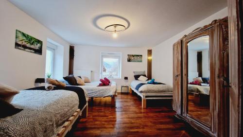 una camera da letto con due letti e uno specchio di Maison de maître & spa a Cornimont