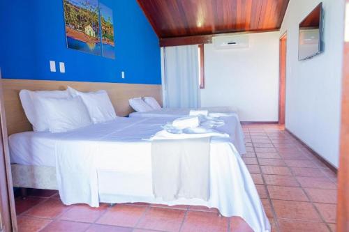 a bedroom with a white bed with a table at Hotel Praia dos Carneiros in Tamandaré