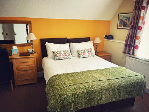 a bedroom with a large bed with two pillows at The Robin Hill in Torquay