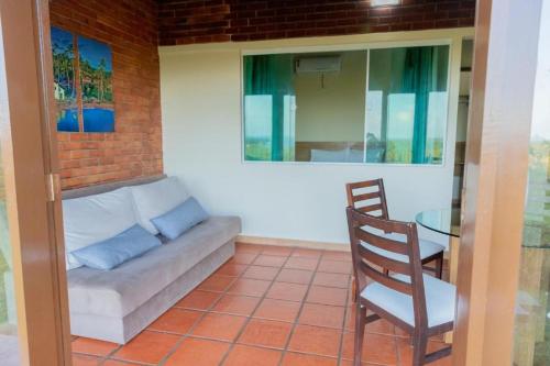 a living room with a couch and a glass table at Hotel Praia dos Carneiros in Tamandaré