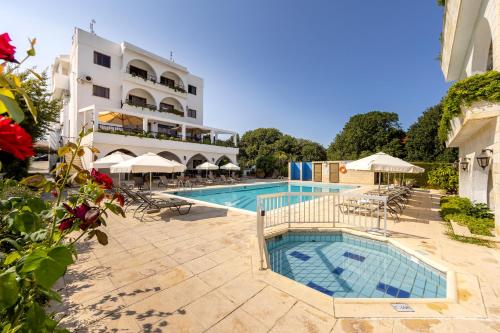 een hotel met een zwembad voor een gebouw bij Stephanos Hotel Apartments in Polis Chrysochous