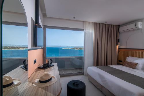a hotel room with a bed and a large window at Mistral Bay Hotel in Agios Nikolaos