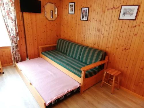 Cette petite chambre comprend un banc vert et un tabouret. dans l'établissement Appartement Le Grand-Bornand, 1 pièce, 4 personnes - FR-1-241-65, au Grand-Bornand