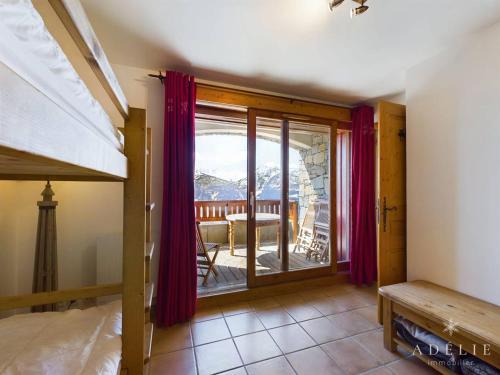 a bedroom with a bunk bed and a balcony at Appartement Montvalezan-La Rosière, 3 pièces, 6 personnes - FR-1-398-588 in Le Châtelard