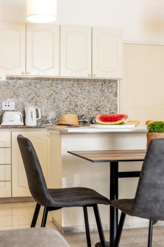 a kitchen with a table with a bowl of watermelon at Stephanos Hotel Apartments in Polis Chrysochous