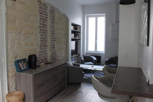 - un salon avec des chaises et un mur en briques dans l'établissement Studio centre-ville Rueil-Malmaison - proche RER A, à Rueil-Malmaison