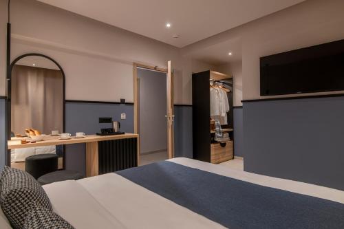 a hotel room with a bed and a desk and a television at Mistral Bay Hotel in Agios Nikolaos