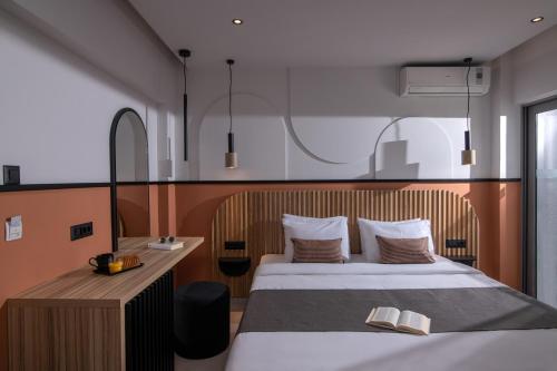 a bedroom with a bed and a desk with two books at Mistral Bay Hotel in Agios Nikolaos