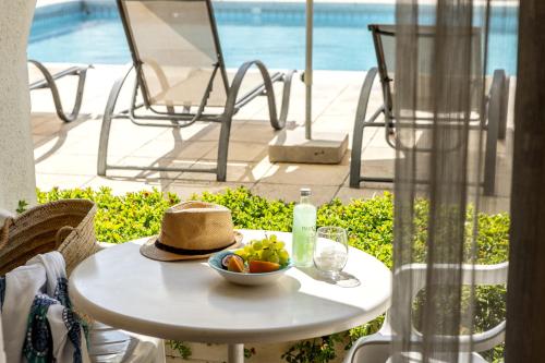 a table with a bowl of fruit and a hat on it at Stephanos Hotel Apartments in Polis Chrysochous