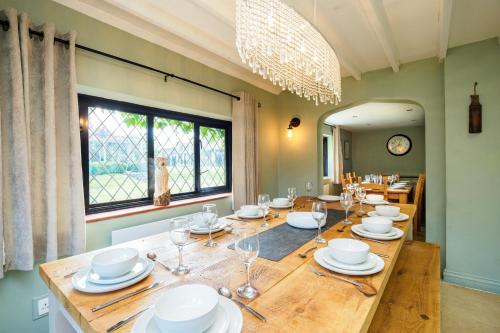a dining room with a large wooden table with glasses at Gildridge in Chiddingly