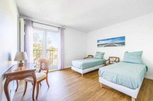 une chambre avec deux lits, une table et une chaise dans l'établissement Appartement Port Santa Lucia - Le Manoir, à Saint-Raphaël