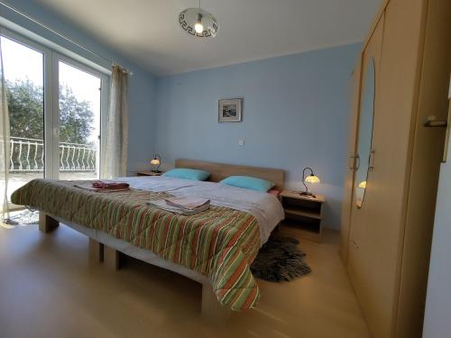 a bedroom with a bed and a large window at Va Zamete in Rijeka